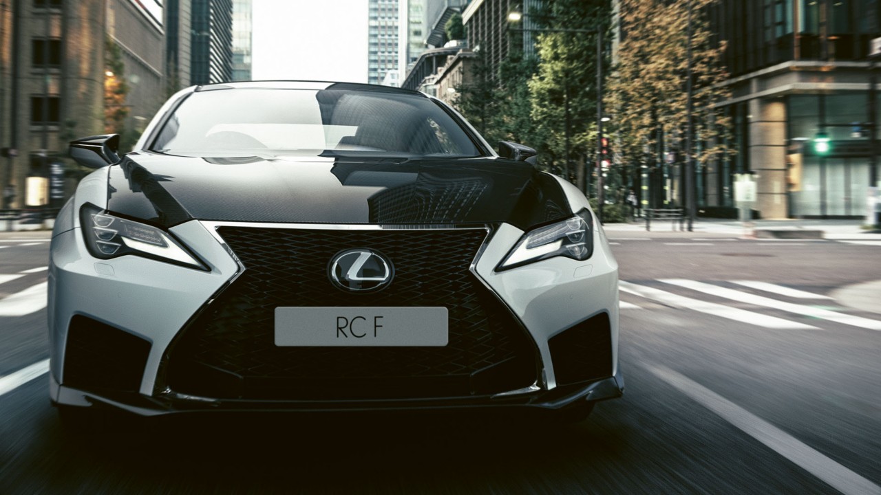 A front close-up of the RC F driving through a city street