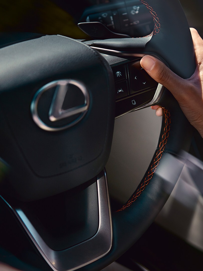 A woman plugging in a charger into a Lexus NX 